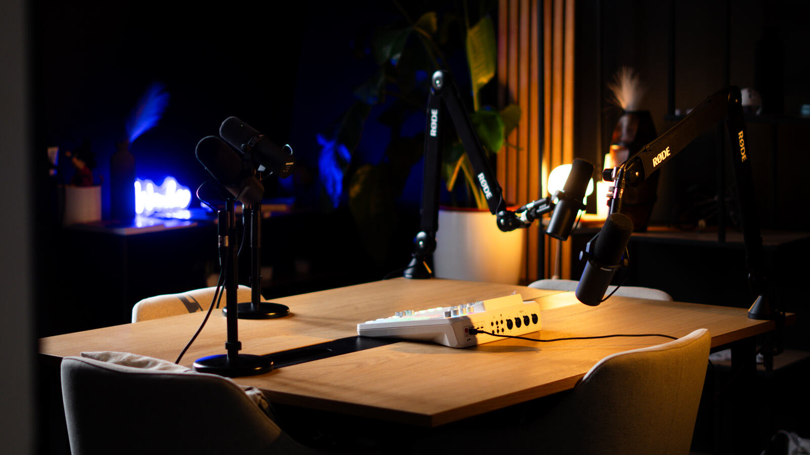 Le studio allumé le soir, deux micros et lampes chaudes sur la table